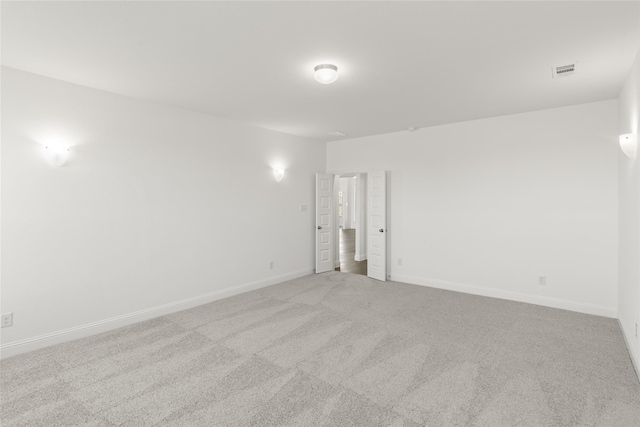 carpeted spare room with baseboards and visible vents