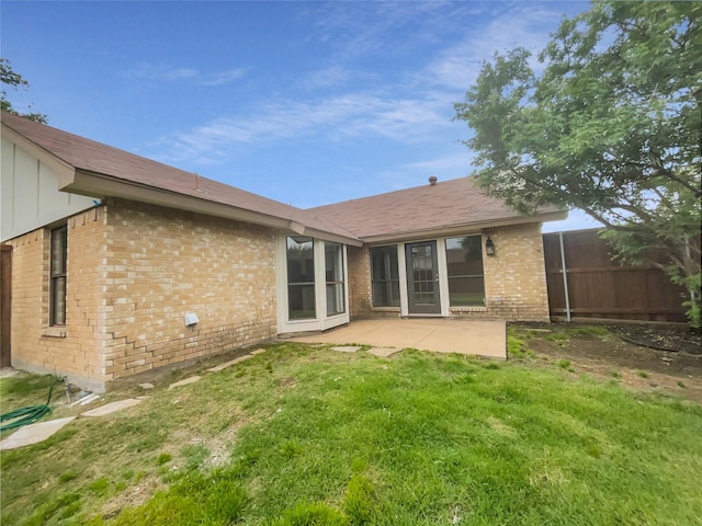 back of house with a lawn and a patio area