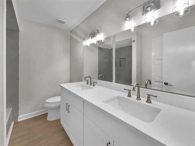 bathroom with toilet, vanity, and hardwood / wood-style floors