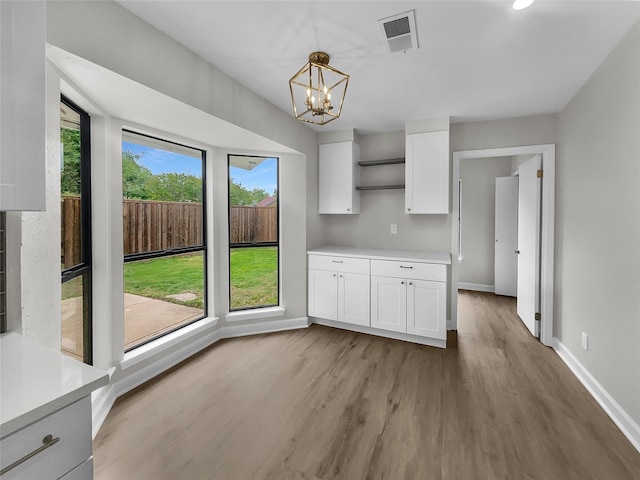 kitchen featuring decorative light fixtures, an inviting chandelier, plenty of natural light, and white cabinets