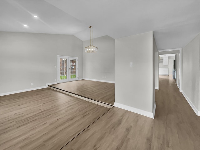 interior space with wood-type flooring, an inviting chandelier, and vaulted ceiling