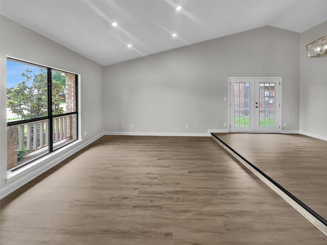 unfurnished room featuring lofted ceiling, french doors, and wood-type flooring