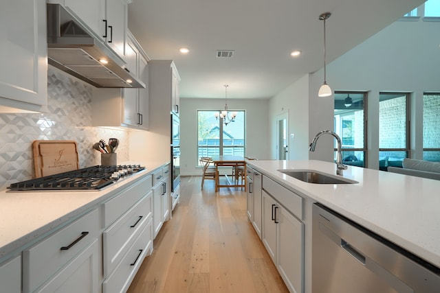 kitchen featuring appliances with stainless steel finishes, a wealth of natural light, pendant lighting, and sink