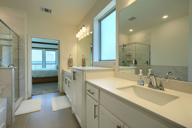 bathroom featuring tile patterned floors, a shower with door, and vanity