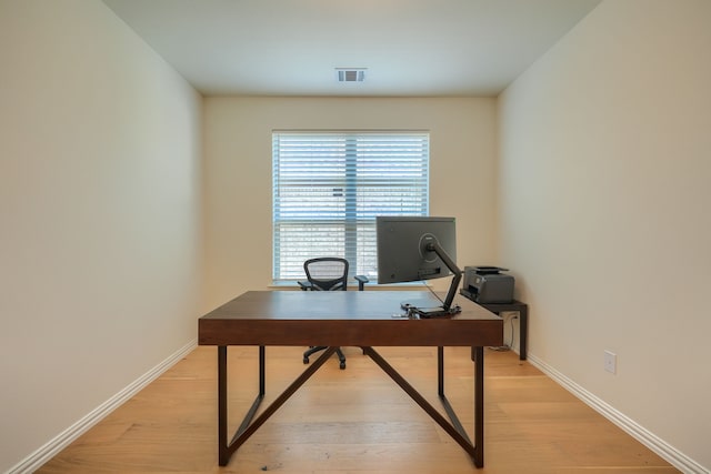 home office with light hardwood / wood-style flooring