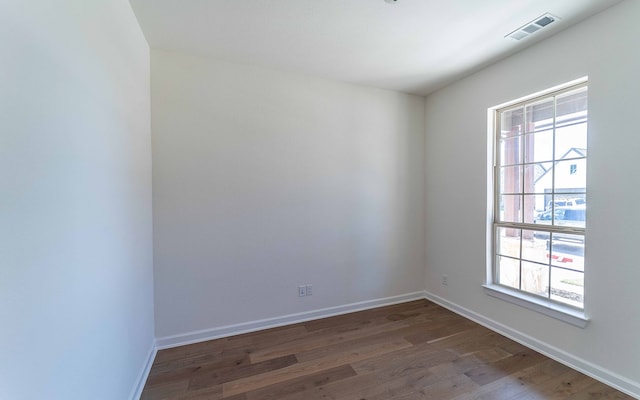 unfurnished room with dark wood-type flooring