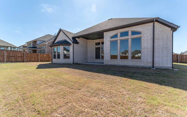 rear view of property with a yard