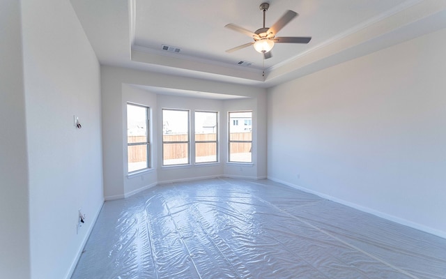 unfurnished room featuring ceiling fan and a tray ceiling