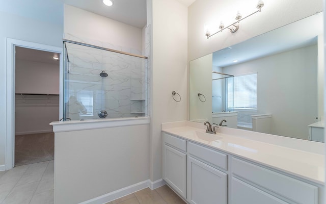 bathroom with tiled shower, tile floors, and vanity