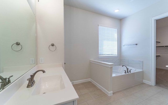 bathroom featuring a washtub, tile flooring, and vanity