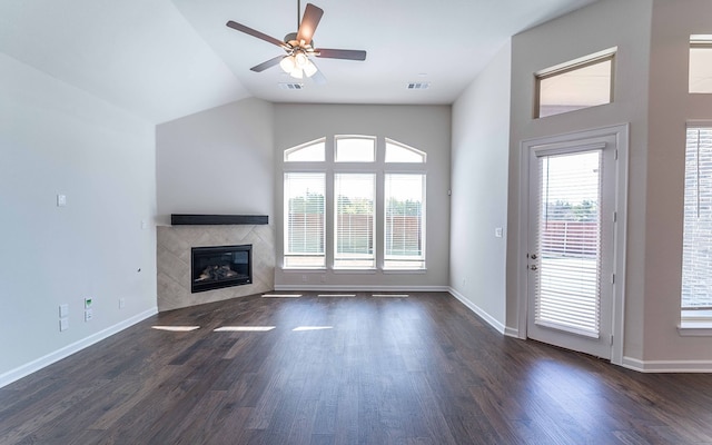 unfurnished living room with dark hardwood / wood-style floors, plenty of natural light, ceiling fan, and a tile fireplace