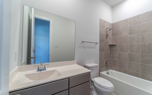 full bathroom featuring tiled shower / bath combo, large vanity, and toilet