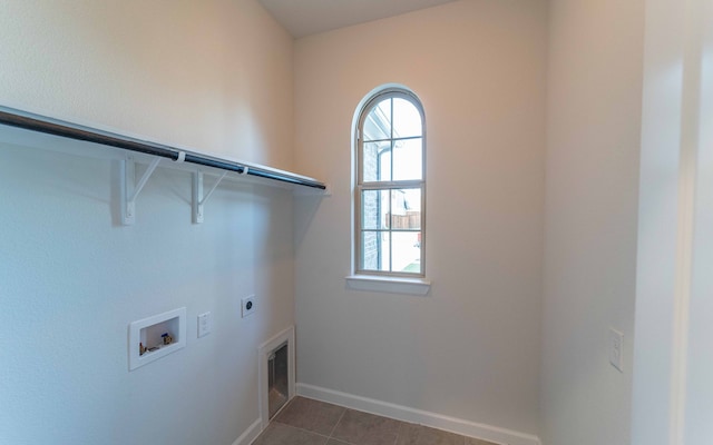 clothes washing area featuring dark tile floors, hookup for a washing machine, and hookup for an electric dryer