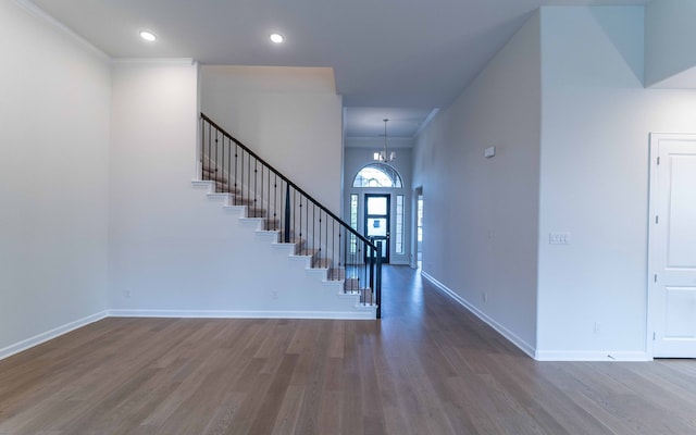 foyer entrance with ornamental molding, dark hardwood / wood-style flooring, and an inviting chandelier