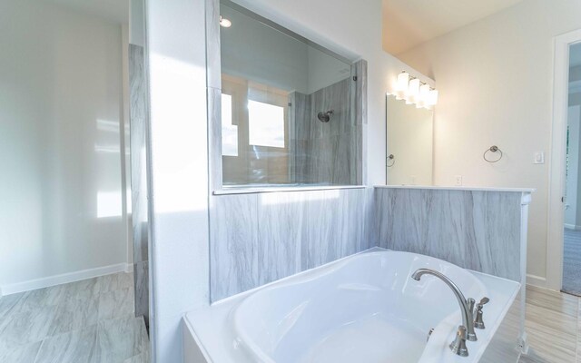 bathroom featuring tiled bath and tile floors