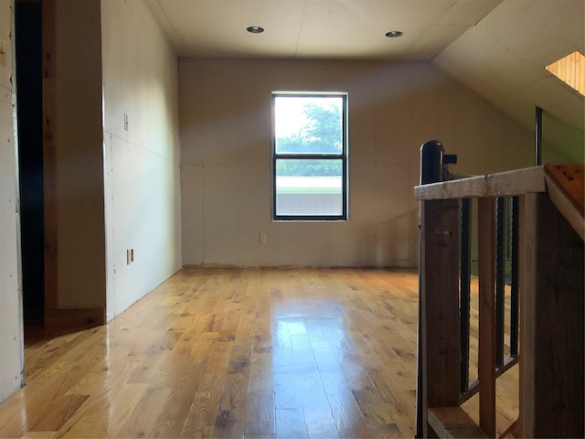 additional living space featuring light hardwood / wood-style flooring and vaulted ceiling