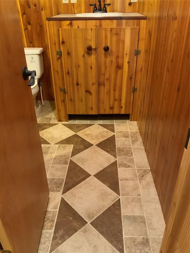 interior space with toilet and wooden walls