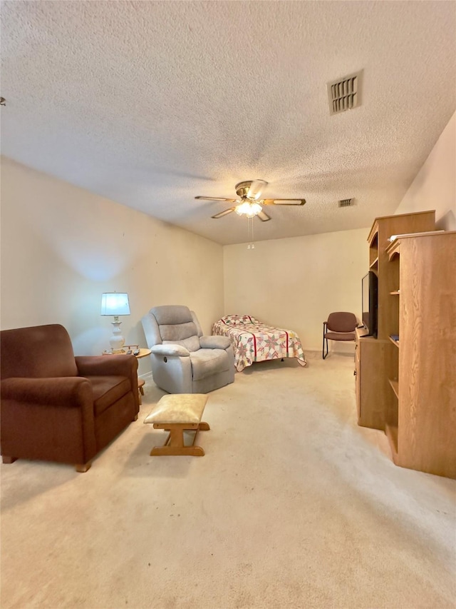 bedroom with a textured ceiling, ceiling fan, and light carpet