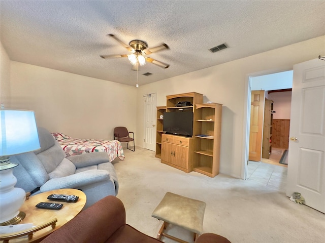 living room with ceiling fan, light colored carpet, and a textured ceiling