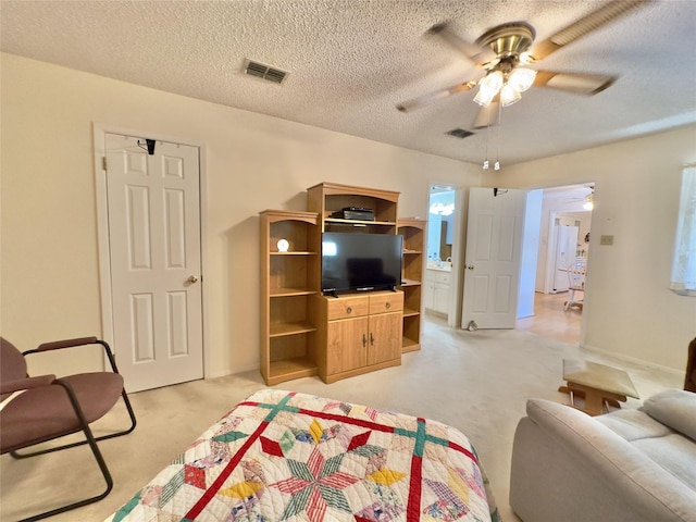 living room with ceiling fan, light colored carpet, and a textured ceiling