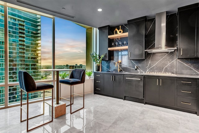 kitchen featuring wall chimney range hood, backsplash, white gas cooktop, sink, and light tile floors