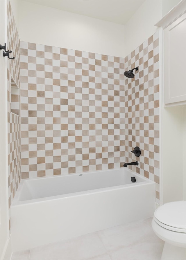 bathroom featuring tile patterned floors, tiled shower / bath, and toilet