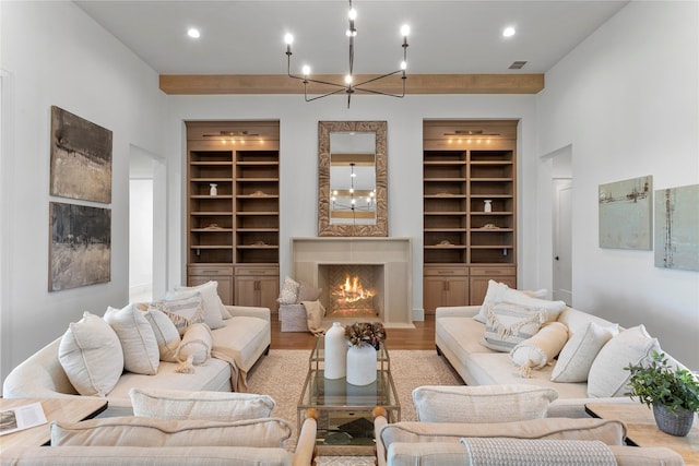 living room with built in shelves, light hardwood / wood-style floors, and beam ceiling