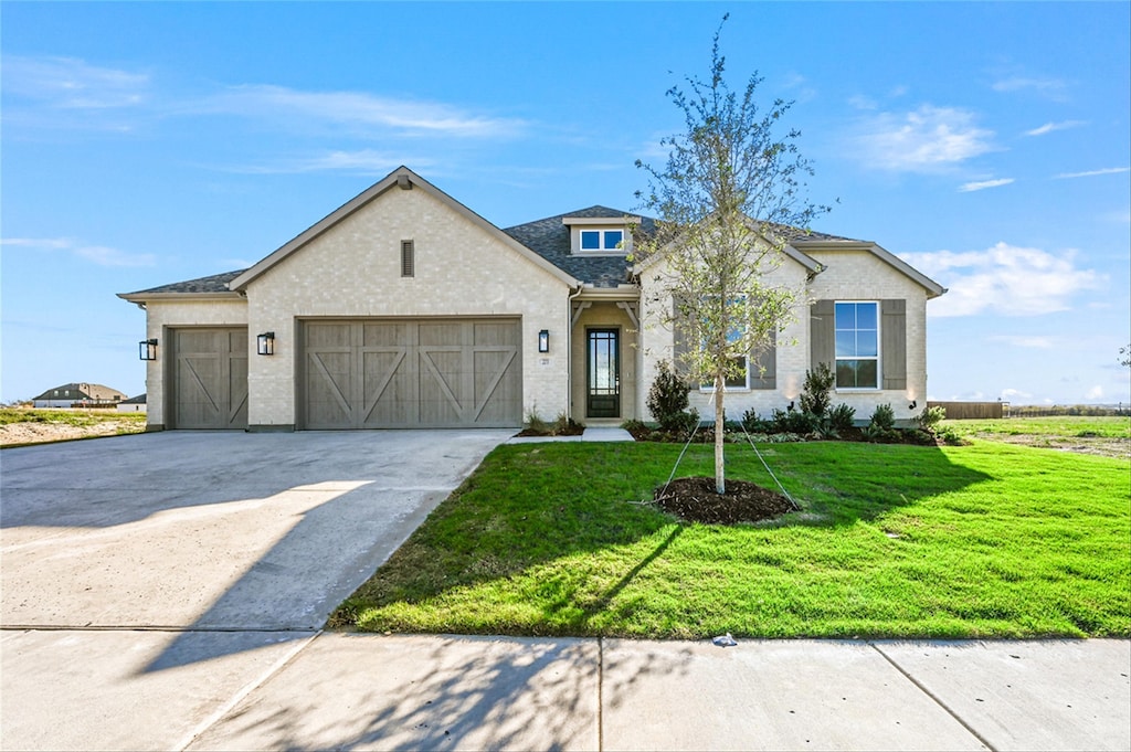 view of front of house featuring a garage and a front lawn