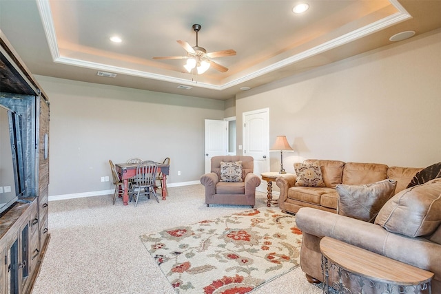 living room with carpet flooring, a ceiling fan, visible vents, baseboards, and a raised ceiling