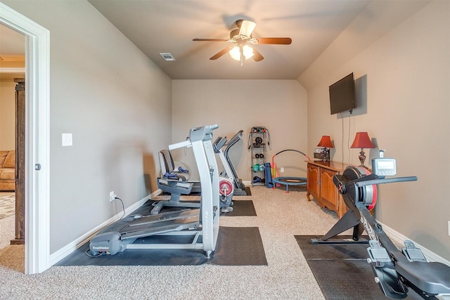 workout area featuring a ceiling fan, visible vents, dark carpet, and baseboards