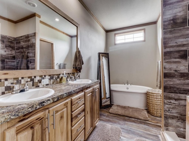 bathroom with tasteful backsplash, vanity, ornamental molding, and hardwood / wood-style flooring