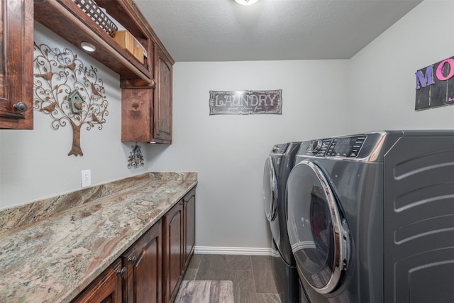 laundry area with cabinets, washing machine and dryer, dark wood-type flooring, and a textured ceiling