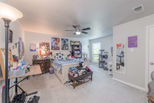 bedroom featuring light carpet, a textured ceiling, and ceiling fan