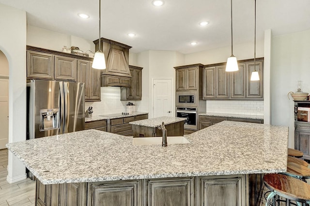 kitchen with a large island, appliances with stainless steel finishes, and tasteful backsplash