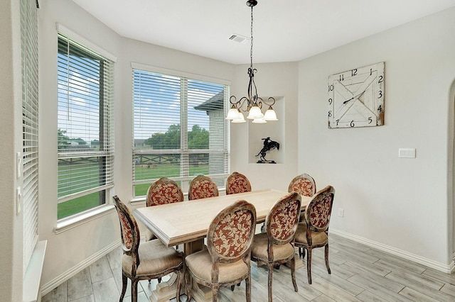 dining area featuring light hardwood / wood-style floors and a notable chandelier