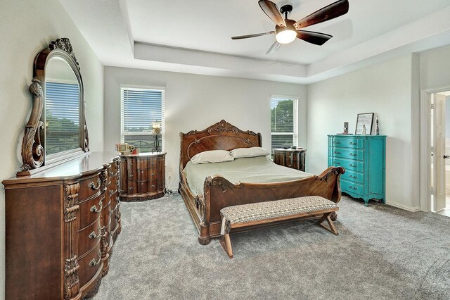 bedroom featuring a tray ceiling, ceiling fan, and light colored carpet