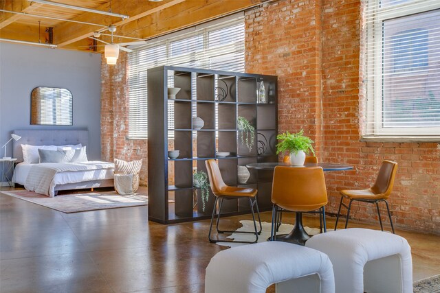 living area with brick wall and beam ceiling