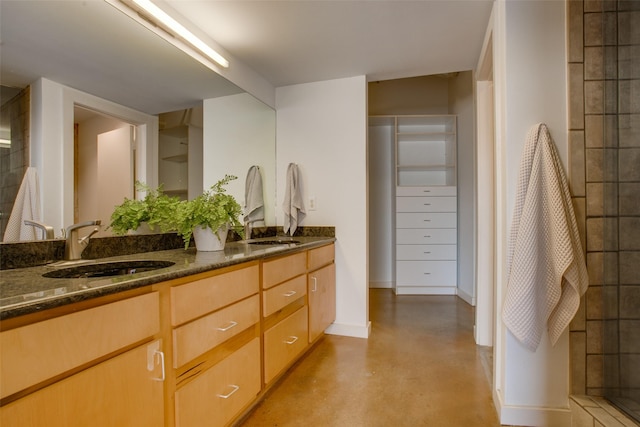 bathroom with a shower, vanity, and concrete floors