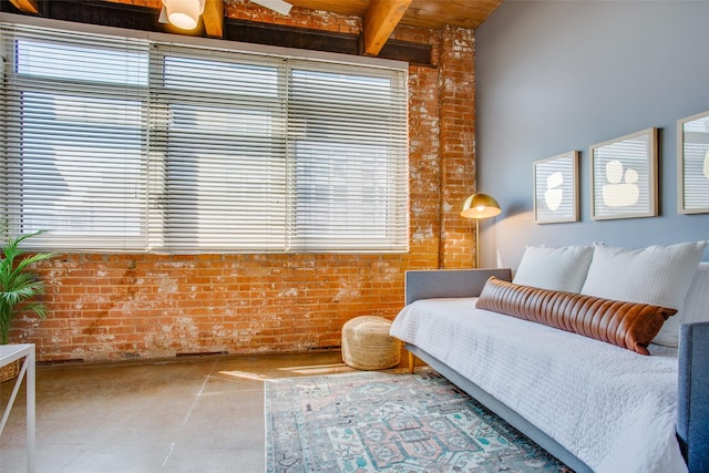 living area with brick wall, wooden ceiling, and beamed ceiling