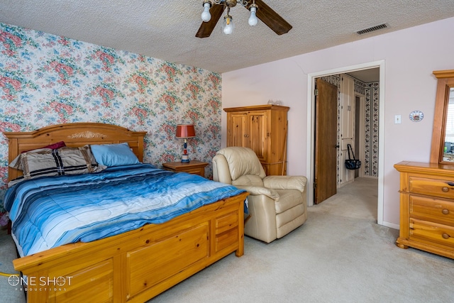 carpeted bedroom with ceiling fan and a textured ceiling