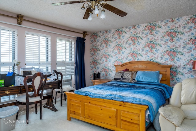 carpeted bedroom featuring a textured ceiling, ceiling fan, and cooling unit