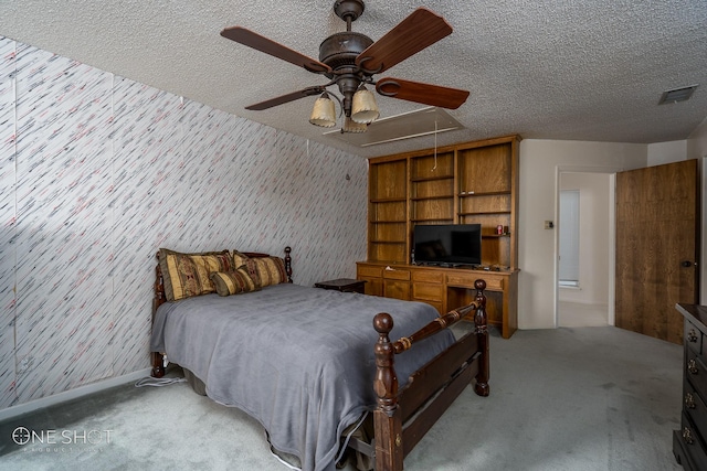 bedroom with ceiling fan, light colored carpet, and a textured ceiling