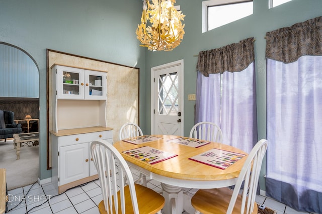 dining area with light tile patterned floors and an inviting chandelier