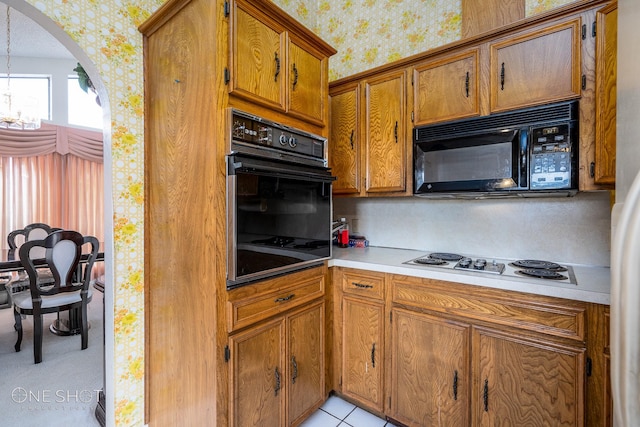 kitchen featuring a chandelier, light tile patterned floors, and black appliances