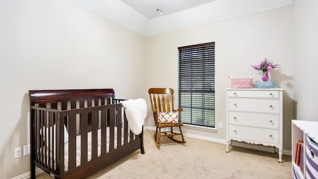 bedroom with light carpet, vaulted ceiling, and a nursery area