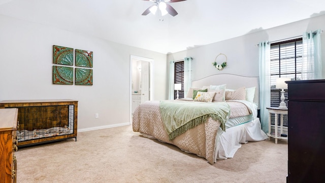 bedroom featuring connected bathroom, light colored carpet, and ceiling fan