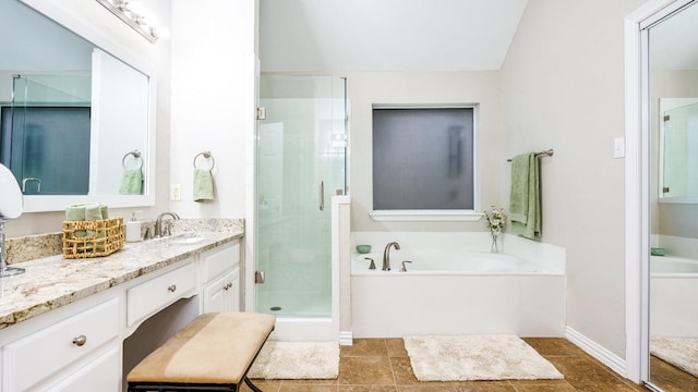 bathroom featuring vanity, independent shower and bath, and vaulted ceiling