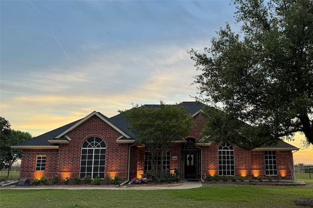 single story home featuring a lawn