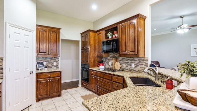 kitchen with light stone countertops, sink, backsplash, and black appliances