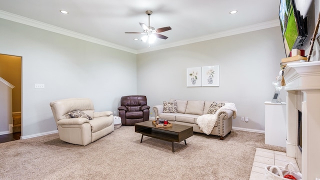 carpeted living room with ceiling fan, crown molding, and a fireplace